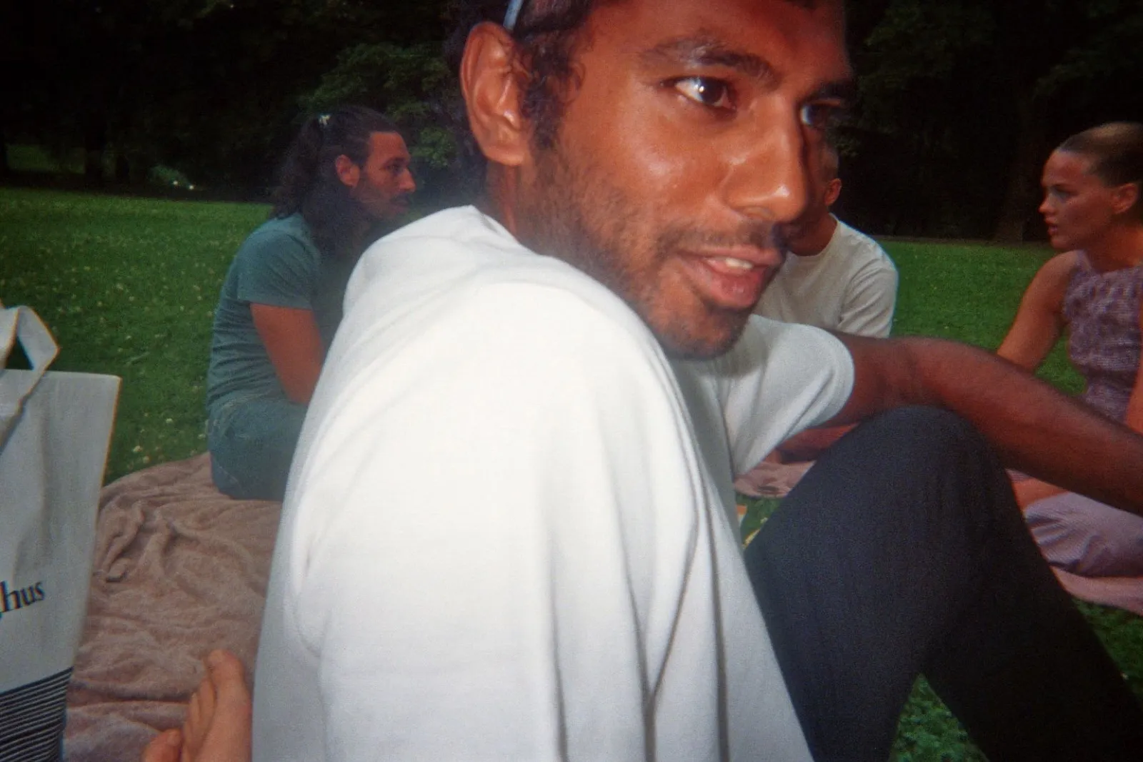 Me at an evening picnic in the park, looking back over my shoulder