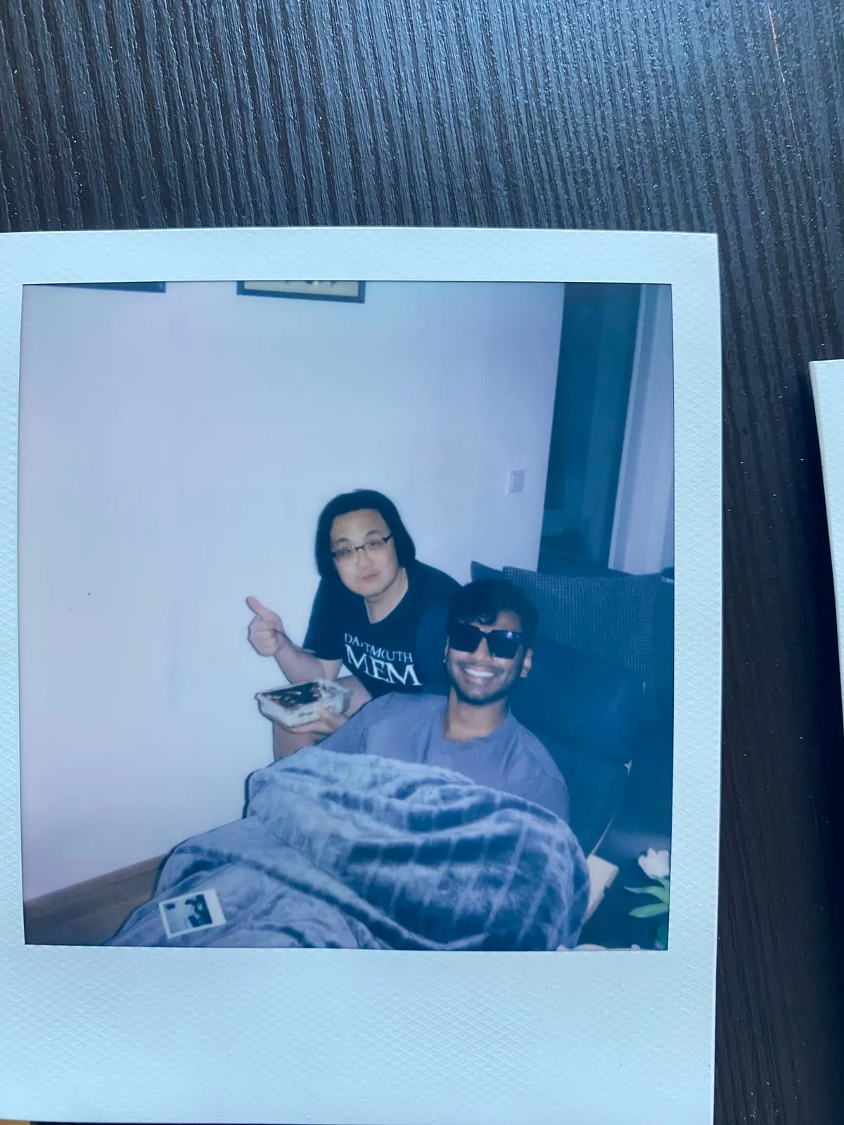 A polaroid of me and a friend indoors, cake in hand