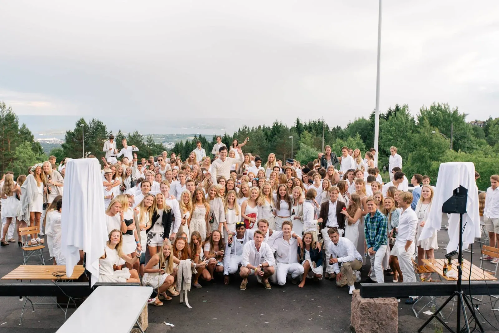 A crowd of us dressed in white on a hillside above Oslo